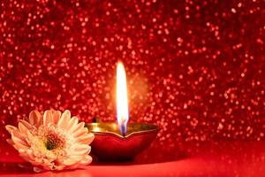 feliz Diwali. queimando lâmpadas de óleo diya e flores sobre fundo vermelho brilhante. celebrando o tradicional festival indiano da luz. foto