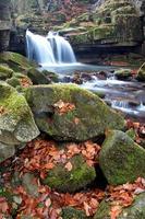 cachoeira de outono e pedras foto