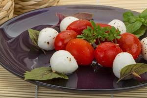 salada caprese no prato e fundo de madeira foto