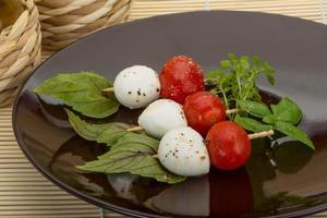 salada caprese no prato e fundo de madeira foto