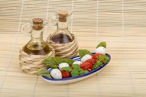 salada caprese em uma tigela com fundo de madeira foto