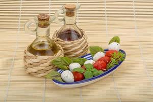 salada caprese em uma tigela com fundo de madeira foto