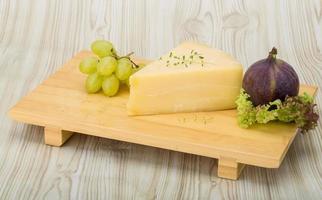 queijo parmesão na tábua de madeira e fundo de madeira foto