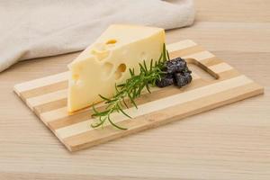 queijo maasdam na placa de madeira e fundo de madeira foto