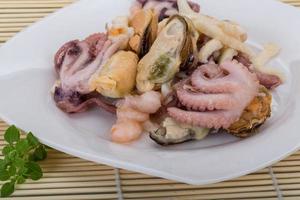 coquetel de frutos do mar no prato e fundo de madeira foto