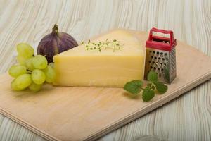 queijo parmesão na tábua de madeira e fundo de madeira foto