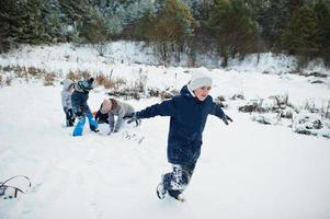 mãe brincando com crianças na natureza do inverno. ao ar livre na neve. foto