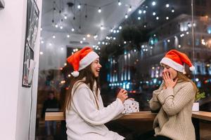 a garota dá um presente para sua amiga no caffe foto