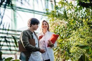 jovens engenheiros agrícolas trabalhando em estufa foto