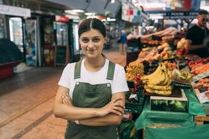 mulher vendedora de frutas no mercado perto do balcão foto