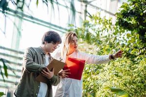 jovens engenheiros agrícolas trabalhando em estufa foto