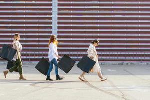 mulheres jovens com sacolas de compras andando na rua. foto