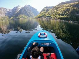 homem controla uma lancha em um lago de montanha foto