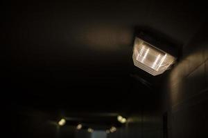 lâmpada no túnel. luz no corredor. escuridão na passagem subterrânea. foto
