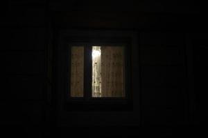 janela está no escuro. cortinas na janela à noite. foto