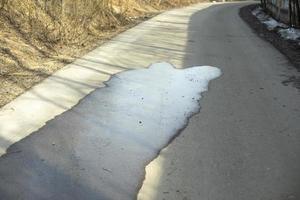 poça no asfalto. estrada molhada. água derramada na zona pedonal. foto