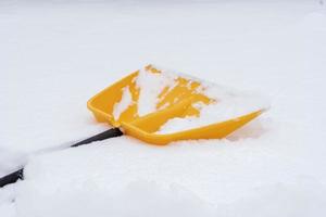 uma pá amarela deitada na neve foto