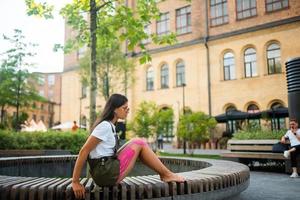 jovem em um banco de parque posando para a câmera foto