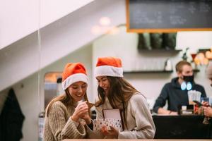 a garota dá um presente para sua amiga no caffe foto