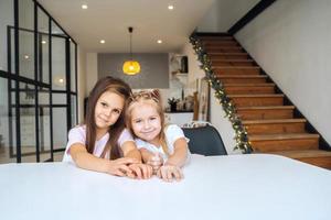 duas meninas na mesa olhando para o close-up da câmera foto