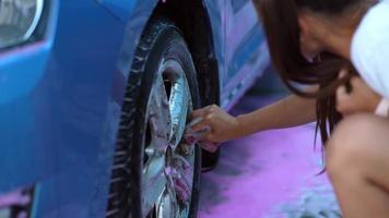 jovem lavando as rodas de seu carro foto