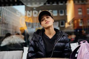 retrato de uma linda mulher sentada em um café ao ar livre foto