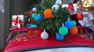 carro retrô vermelho com um abeto de árvore de natal amarrado ao telhado. foto