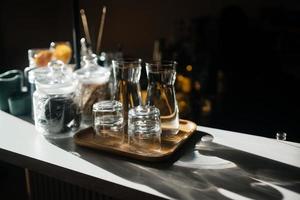 quatro copos de vidro no balcão do bar com acessórios para servir. foto