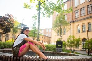 jovem em um banco de parque posando para a câmera foto