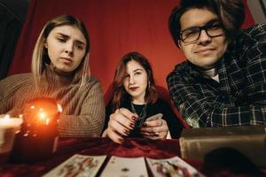 grupo de pessoas e mulher cartomante com bola de cristal foto