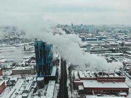grande sala de caldeira central com tubos gigantes dos quais há fumaça perigosa no inverno durante a geada em uma cidade grande foto