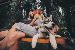 lindo casal junto com cachorro em um balanço foto