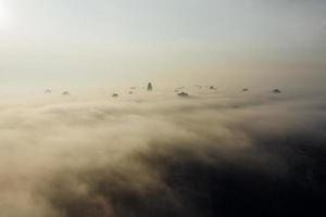 vista aérea da cidade no nevoeiro. arranha-céus acima do nevoeiro foto