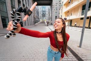 jovem blogueira feminina com smartphone streaming na rua. foto