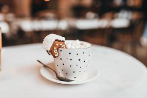 a caneca com as decorações de natal e biscoito na borda foto