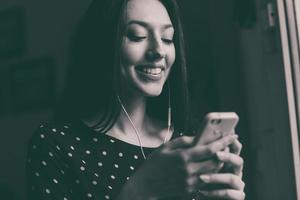 menina bonita, ouvindo música no telefone com fones de ouvido foto