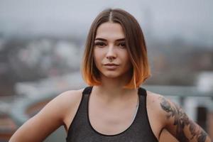 garota posa no telhado de um prédio no centro da cidade. fotografia de retrato foto