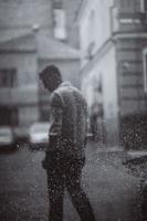 retrato de jovem bonito despreocupado está se sentindo livre sob a chuva foto