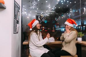 a garota dá um presente para sua amiga no caffe foto