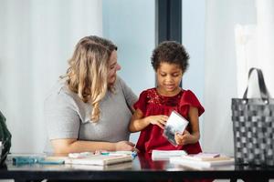 mãe e filha filha desenha criativamente na mesa foto