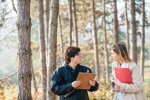 cientistas estão estudando espécies de plantas e inspecionando árvores na floresta. foto