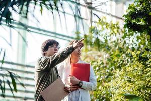 jovens engenheiros agrícolas trabalhando em estufa foto