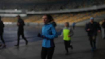 as pessoas praticam esportes no estádio noturno em tempo chuvoso foto