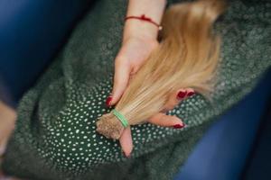 jovem segurando seu cabelo castanho comprido recém-cortado em rabos de cavalo foto