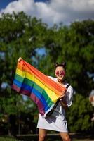 jovem segurando uma bandeira do orgulho lgbt nas mãos dela. foto