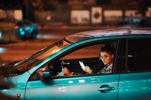 motorista feminina perdida usando telefone celular enquanto dirigia à noite. foto