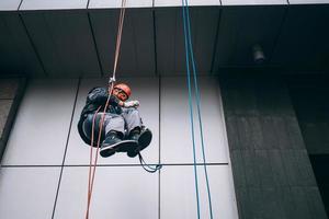 alpinista industrial em uniforme e capacete sobe foto