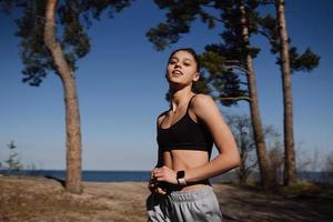 jovem fitness caminha no parque e posando para a câmera foto