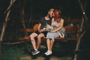 lindo casal junto com cachorro em um balanço foto