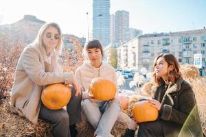 meninas tem abóboras nas mãos no fundo da rua. foto